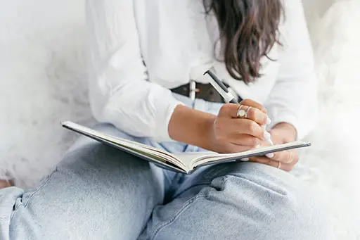 A woman writing in her reflection journal.